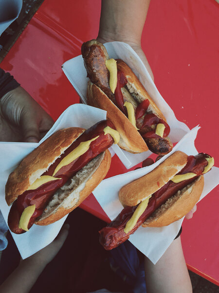 people enjoying some hot dogs together