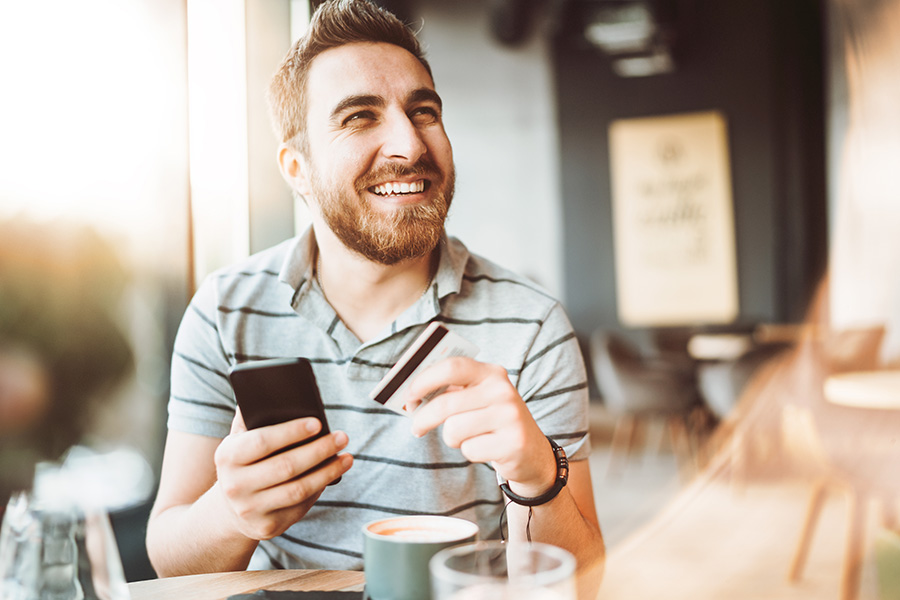 young man shopping online with credit card using smart phone in