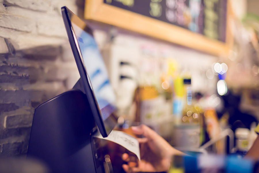 Blurry picture of cashier is printing receipt with cash register